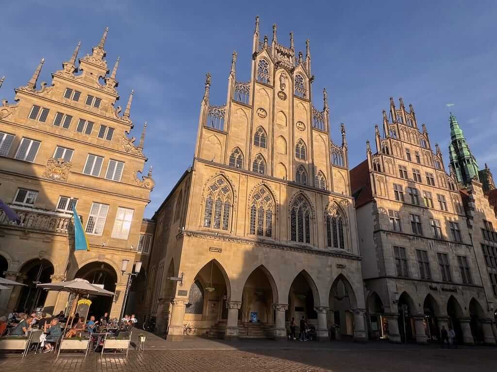 Historisch stadhuis in Münster, verlicht door de avondzon